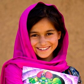 A 9 year-old girl with a story book outside her home in her village in Khyber Pakhtunkhwa Province, Pakistan. Photo Credit: Asad Zaidi/Save the Children 2014. A 9 year-old girl with a story book outside her home in her village in Khyber Pakhtunkhwa Province, Pakistan. Photo Credit: Asad Zaidi/Save the Children 2014.