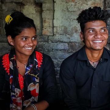 Two young adults sing together and smile at the camera. Two young adults sing together and smile at the camera.