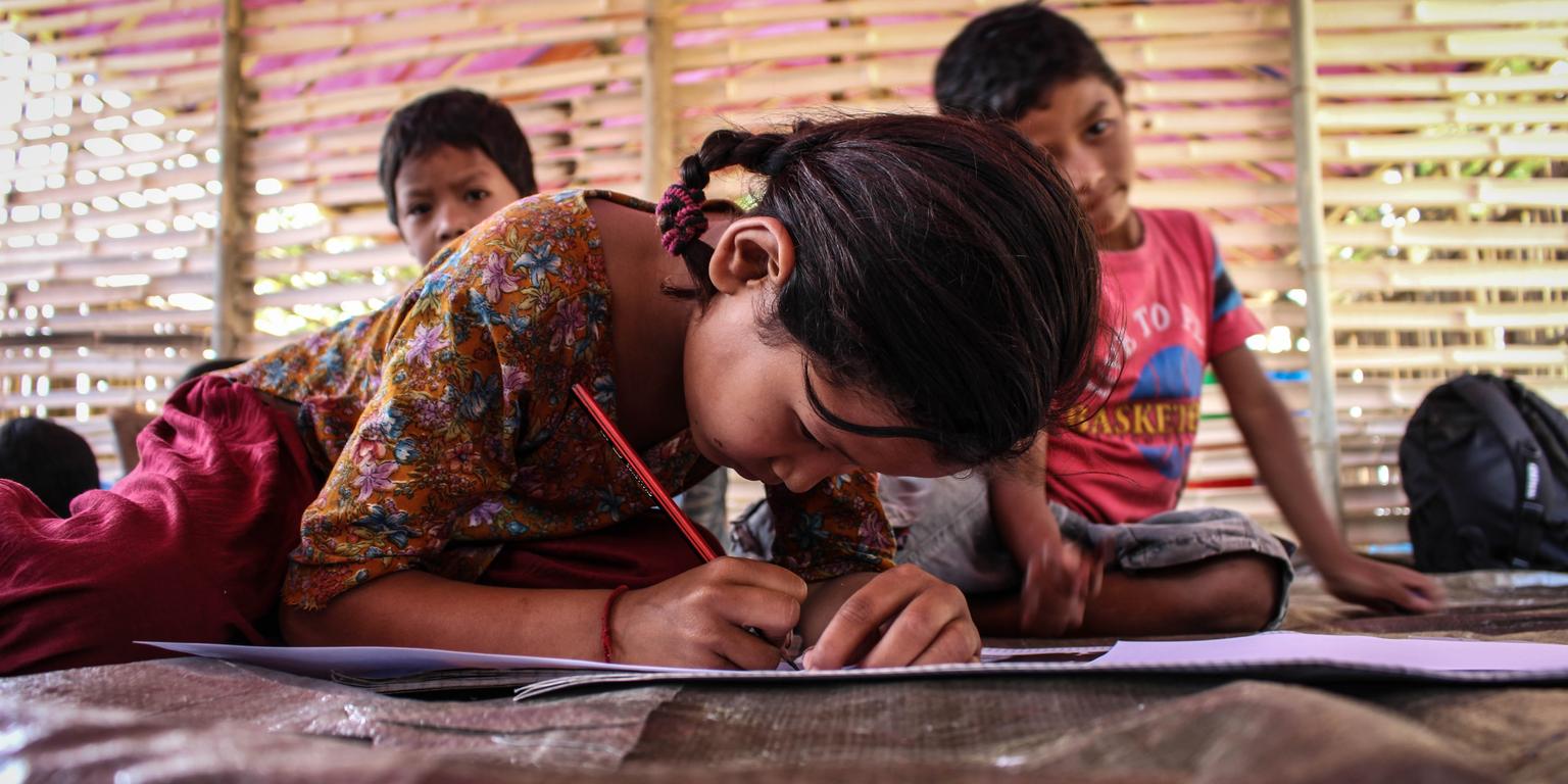 A Nepalese studies at a temporary learning center built by Save the Children. Her school was badly damaged and was not usable for teaching. Save the Children worked with the community to build a temporary learning center, which was completed, and used to teach students, a week before the official Back to School date. Photo Credit: David Hartman/Save the Children 2015. A Nepalese studies at a temporary learning center built by Save the Children. Her school was badly damaged and was not usable for teaching. Save the Children worked with the community to build a temporary learning center, which was completed, and used to teach students, a week before the official Back to School date. Photo Credit: David Hartman/Save the Children 2015.