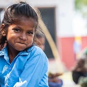 A girl in a blue shirt smiles at the camera. A girl in a blue shirt smiles at the camera.