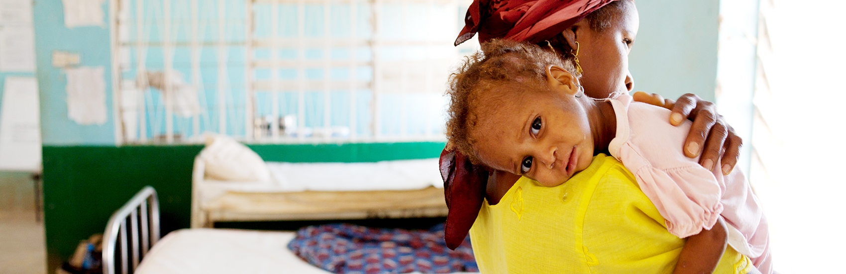 When Farida brought her one-year-old daughter to this Save the Children-supported, government-run facility, she thought she would die. Now the little girl in her arms has improved greatly, and is even playing with other children at the clinic. Photo Credit: Lucia Zoro/Save the Children 2011.