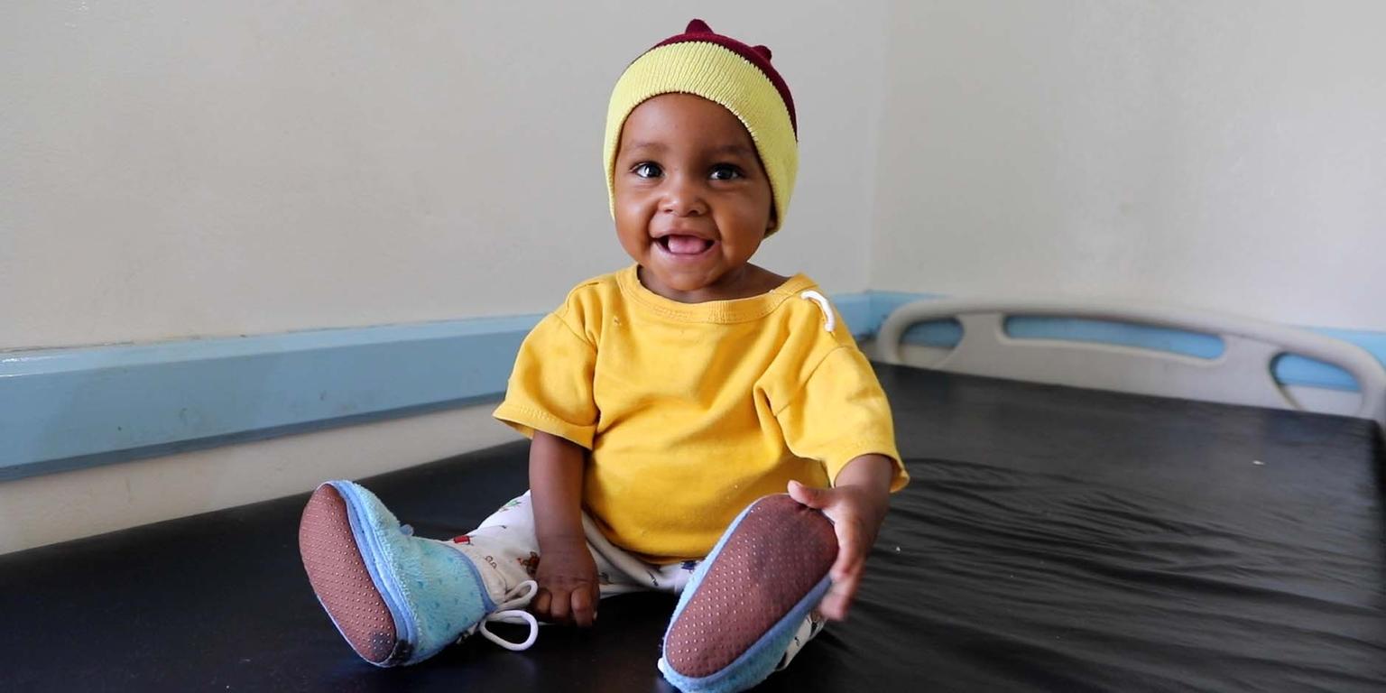 Cute little baby girl named, Noor sitting up on a bed Cute little baby girl named, Noor sitting up on a bed