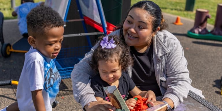 teacher reading a book to 3-year-old boy and girl teacher reading a book to 3-year-old boy and girl