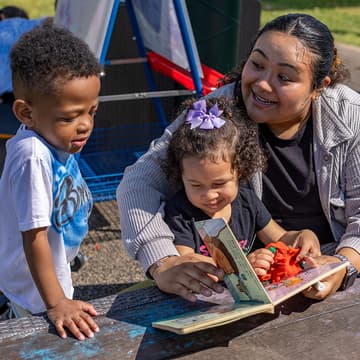 Two children listen to a story being read by an Early Head Start teacher Two children listen to a story being read by an Early Head Start teacher