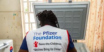 A Kenya, a Save the Children health worker wears a vest that reads: Pfizer Foundations A Kenya, a Save the Children health worker wears a vest that reads: Pfizer Foundations