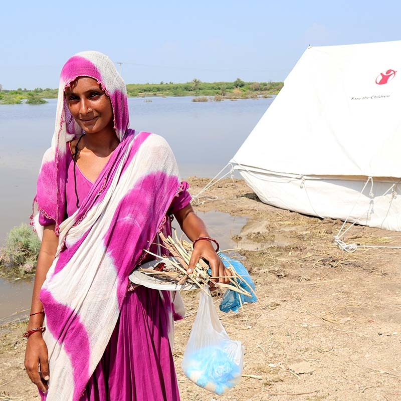 In Pakistan, a woman who lost her home in the dealdy flooding stands near a temporary shelter provided by Save the Children. In Pakistan, a woman who lost her home in the dealdy flooding stands near a temporary shelter provided by Save the Children.