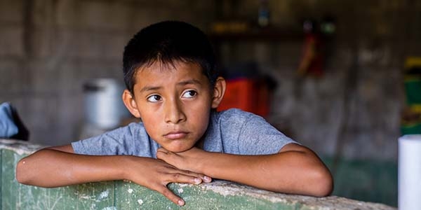 11-year-old Anderson rests his head on his hands while sitting inside his home in El Salvador. 11-year-old Anderson rests his head on his hands while sitting inside his home in El Salvador.