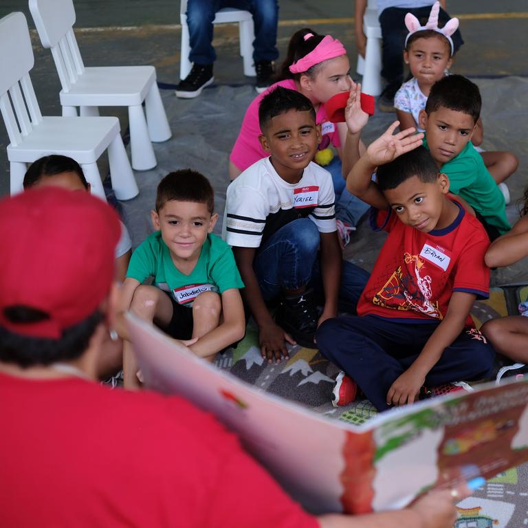 A group of children enjoys story time lead by Save the Children Education Coordinator Maritza Erazo during a community event at the Mulitas Community Center in Puerto Rico. Photo credit: Shawn Millsaps / Save the Children 2018. A group of children enjoys story time lead by Save the Children Education Coordinator Maritza Erazo during a community event at the Mulitas Community Center in Puerto Rico. Photo credit: Shawn Millsaps / Save the Children 2018.