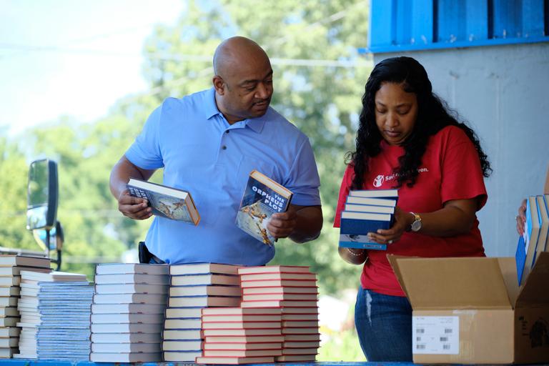 TN, Save the Children staff and volunteers organize books for families. TN, Save the Children staff and volunteers organize books for families.