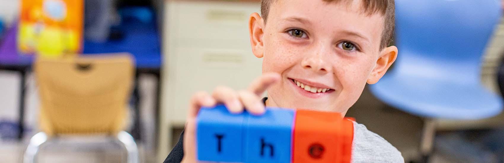 In a classroom in rural America, a 6-year-old boy assembles letter blocks to spell out one of his sight words 'the' during a classroom activity in an Kentucky school.