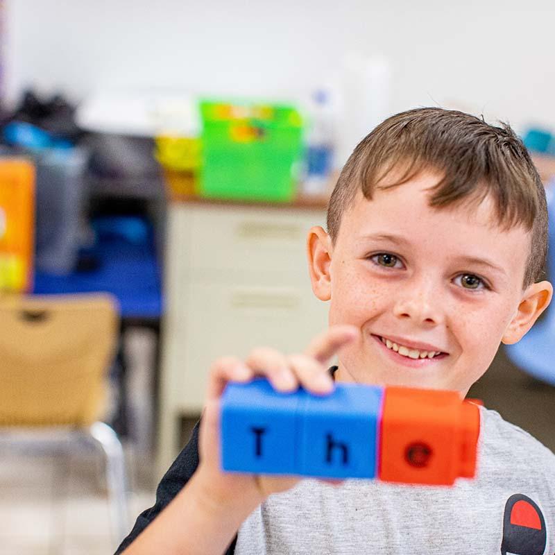 In a classroom in rural America, a 6-year-old boy assembles letter blocks to spell out one of his sight words 'the' during a classroom activity in an Kentucky school.