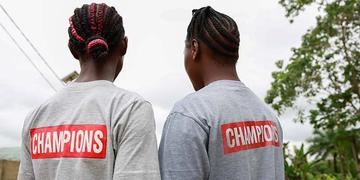 Two girls wear their "Ending Child Marriage Champion" t-shirts in Kailahun, Sierra Leone. Two girls wear their "Ending Child Marriage Champion" t-shirts in Kailahun, Sierra Leone.