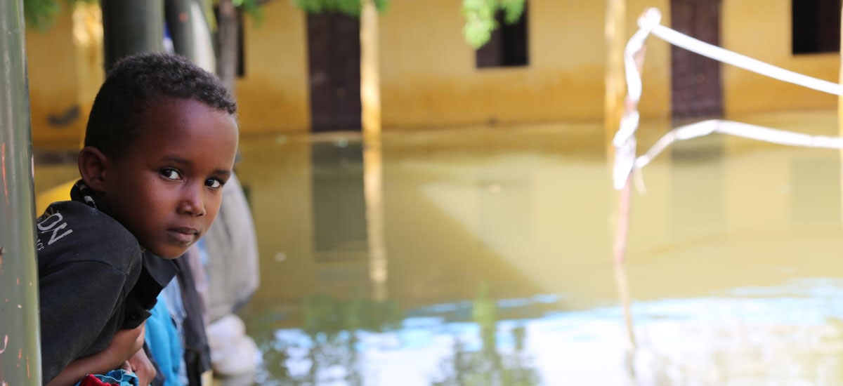 A boy in Somalia looks out over flooded streets