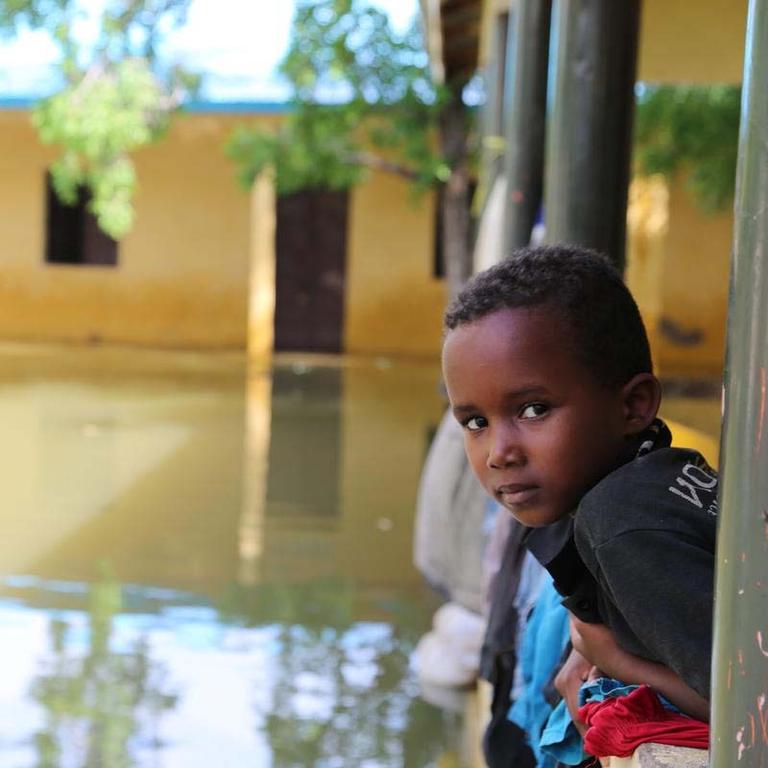 In Somalia, a boy looks out over a flooded river. In Somalia, a boy looks out over a flooded river.