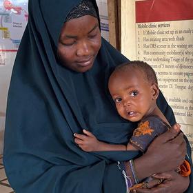 A refugee woman in Somalia is shown holding her baby daughter. A refugee woman in Somalia is shown holding her baby daughter.