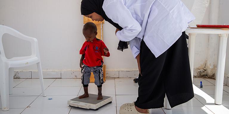 Abdi*, 17 months, standing on a weighing scale in a malnutrition center in Somaliland Abdi*, 17 months, standing on a weighing scale in a malnutrition center in Somaliland