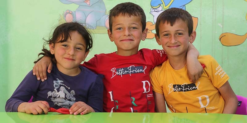 West Viginia, a two girls stand in a library and smile at the camera