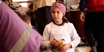 A girl who was injured by the recent earthquakes in Turkey stands in a crowd. A girl who was injured by the recent earthquakes in Turkey stands in a crowd.