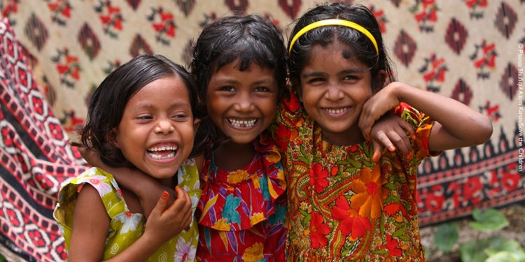 Three young girls pose for a photograph. Three young girls pose for a photograph.
