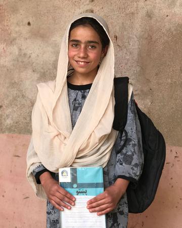 A girl in Afghanistan holds a notebook A girl in Afghanistan holds a notebook