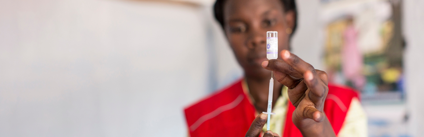 A syringe is prepared for treatment by a medical professional in Uganda.