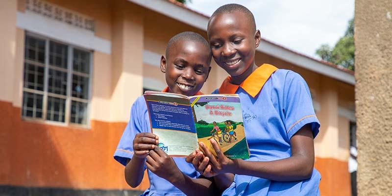 Uganda, Sarah, 13, reads a book with her little sister. Uganda, Sarah, 13, reads a book with her little sister.
