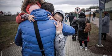 In Ukraine, a girl wears a coat while standing in line with others who have been forced to flee due to conflict. In Ukraine, a girl wears a coat while standing in line with others who have been forced to flee due to conflict.