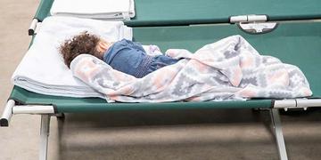 A child sleeps on a cot. A child sleeps on a cot.