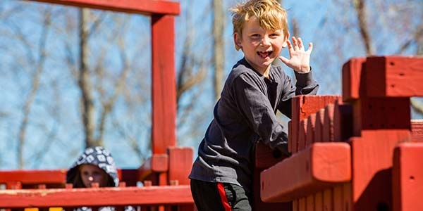 A boy waves to the camera. A boy waves to the camera.