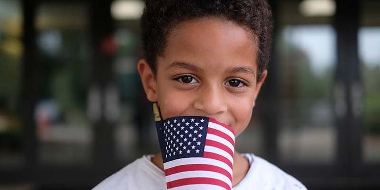 A boy holds an American flag A boy holds an American flag