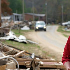 A woman in a baseball hat and red Save the Children sweatshirt brings aid during a disaster A woman in a baseball hat and red Save the Children sweatshirt brings aid during a disaster
