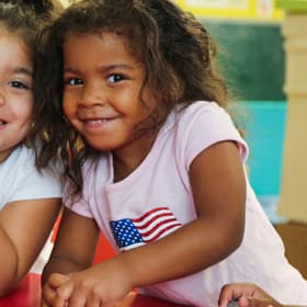 Two young girls smile while playing at a table inside a designated safe area designed by Save the Children in the aftermath of Hurricane Harvey. Two young girls smile while playing at a table inside a designated safe area designed by Save the Children in the aftermath of Hurricane Harvey.