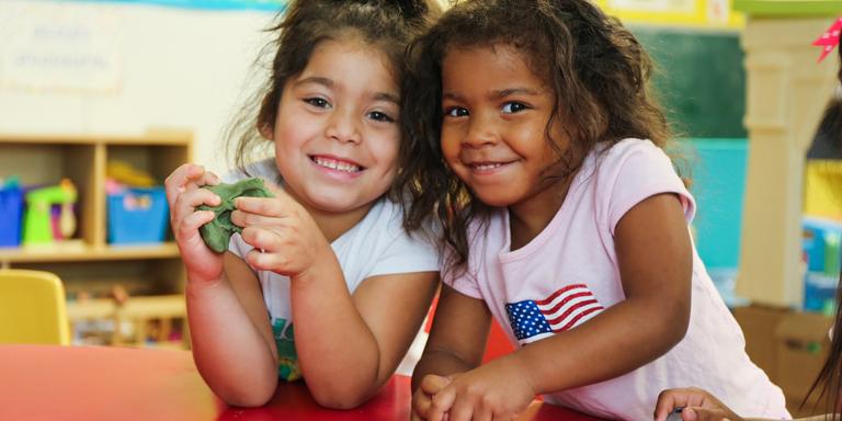 Two young girls smile while playing at a table inside a designated safe area designed by Save the Children in the aftermath of Hurricane Harvey. Two young girls smile while playing at a table inside a designated safe area designed by Save the Children in the aftermath of Hurricane Harvey.