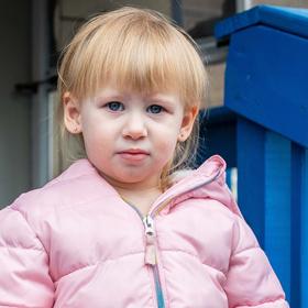 A girl wears a winter coat while standing outside a home in West Virginia. A girl wears a winter coat while standing outside a home in West Virginia.