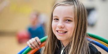 A young girl holding three hula hoops smiles ch21097 A young girl holding three hula hoops smiles ch21097