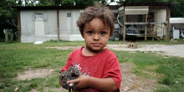 A young child stands in front of their home during a home visit from ±¬ÁÏÿÈÕ´óÈü to deliver food. A young child stands in front of their home during a home visit from ±¬ÁÏÿÈÕ´óÈü to deliver food.