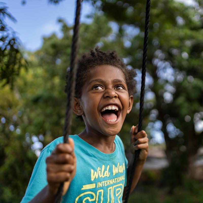 A young girl in Vanuatu plays on a swing A young girl in Vanuatu plays on a swing