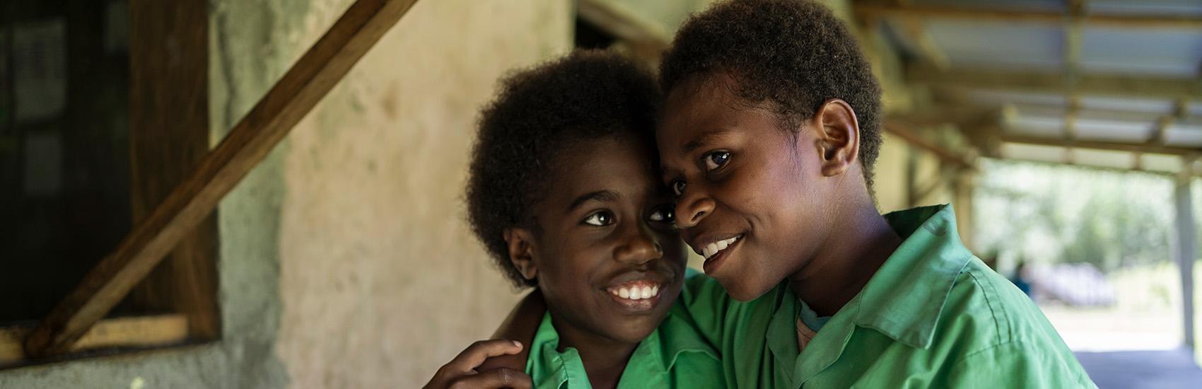 Sylvie and her friend Florence walking to the school library together in Vanuatu