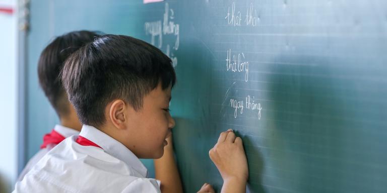 Children in Vietnam write on a chalkboard. Children in Vietnam write on a chalkboard.