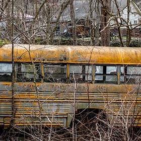 An abandon yellow school bus with broken windows rust in a field in County, West Virginia. An abandon yellow school bus with broken windows rust in a field in County, West Virginia.