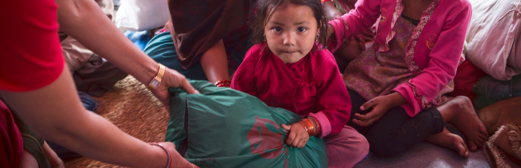 Aswini, age four, lived with her family in a tent settlement in Nepal after the earthquake. Save the Children provided displaced families, including Aswini’s, essential items including infant kits, warm clothes, hats and blankets as well as hygiene kits. Photo credit: Jonathan Hyams/Save the Children, April 2015.