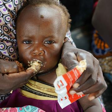 A baby eats emergency food pouch. A baby eats emergency food pouch.