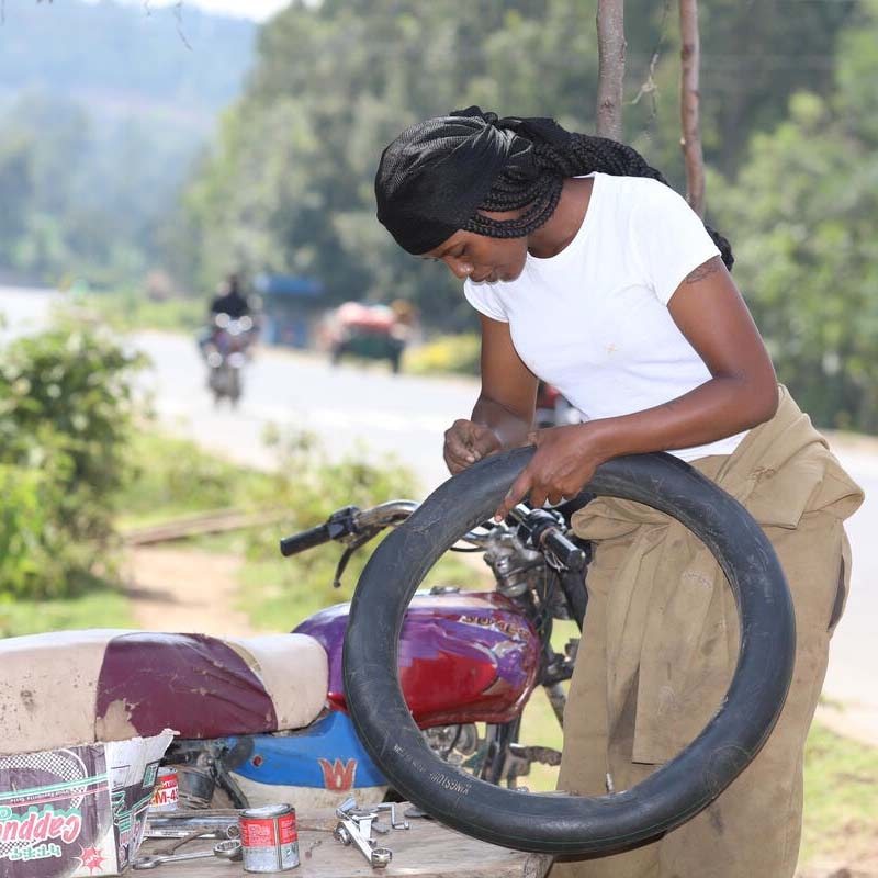 A girl holds a tire to demonstrate the skills she learned through Save the Children's Young Women's Leadership & Economics Empowerment Program (LEEP) in Ethiopia.