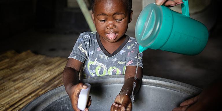 A toddler washes his hands in a basin in Zambia A toddler washes his hands in a basin in Zambia